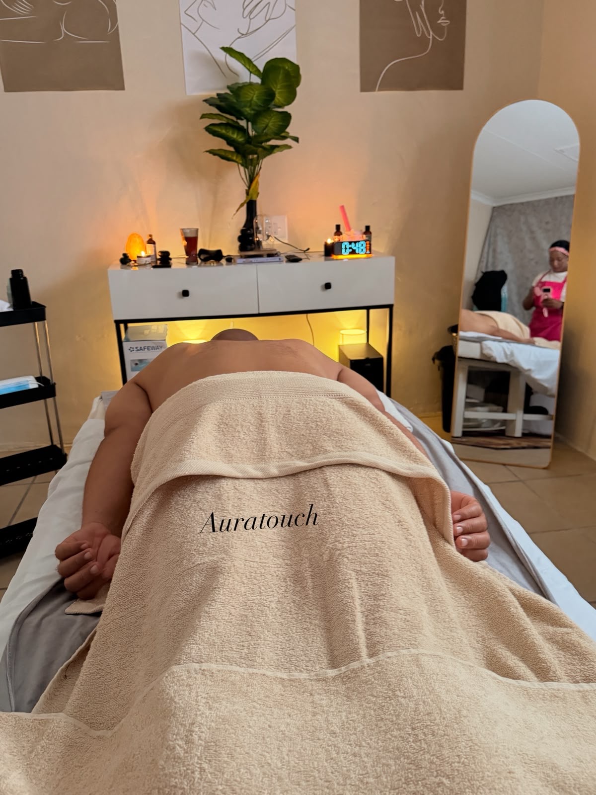 A client draped in an Auratouch towel on the massage bed